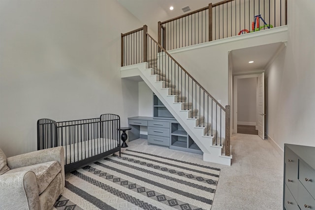 interior space with a towering ceiling and carpet floors