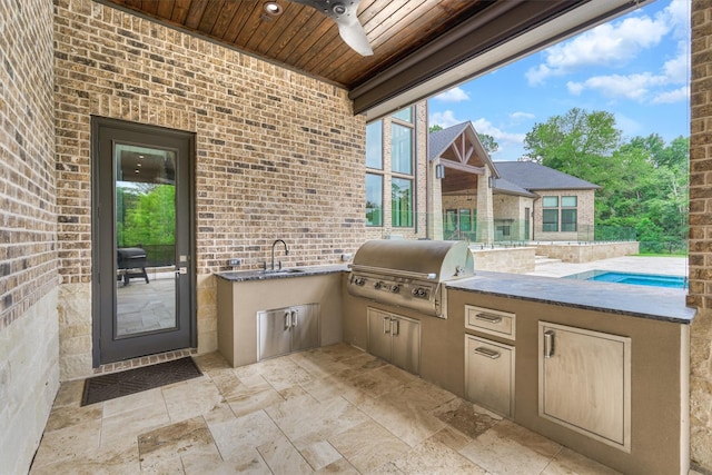 view of patio / terrace featuring ceiling fan, exterior kitchen, sink, and grilling area