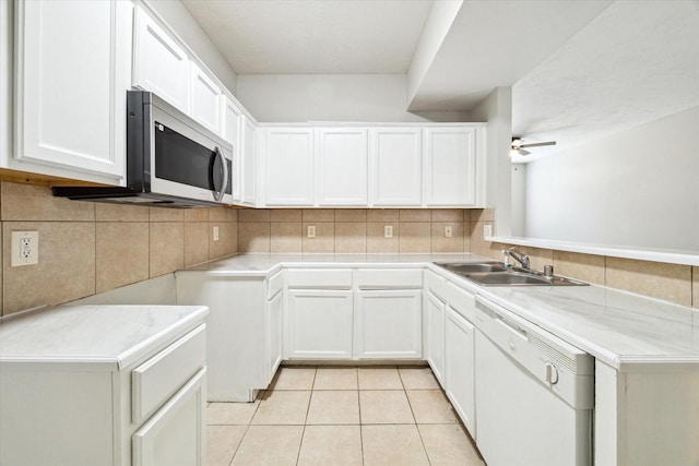 kitchen featuring ceiling fan, sink, light tile patterned floors, white dishwasher, and white cabinets