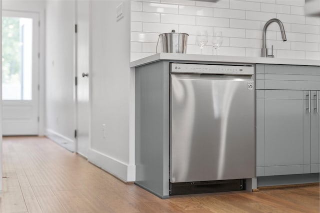 kitchen with dishwasher, tasteful backsplash, gray cabinets, and sink