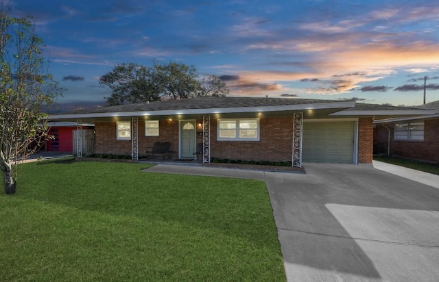 ranch-style house featuring a garage, a carport, and a lawn