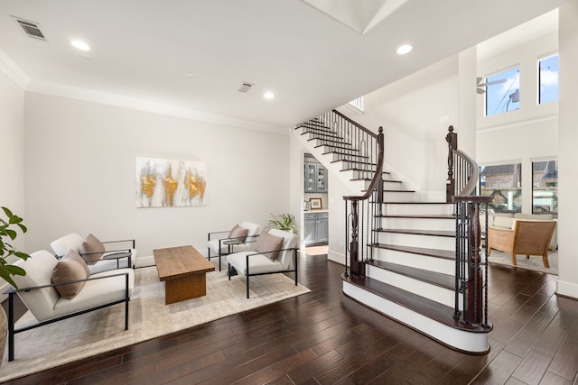 stairway with hardwood / wood-style floors and ornamental molding