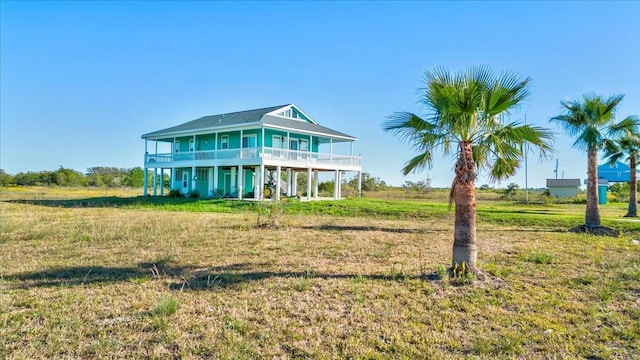 view of front of house featuring a balcony and a front lawn