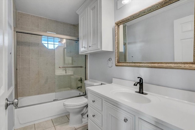 full bathroom featuring combined bath / shower with glass door, vanity, tile patterned floors, and toilet