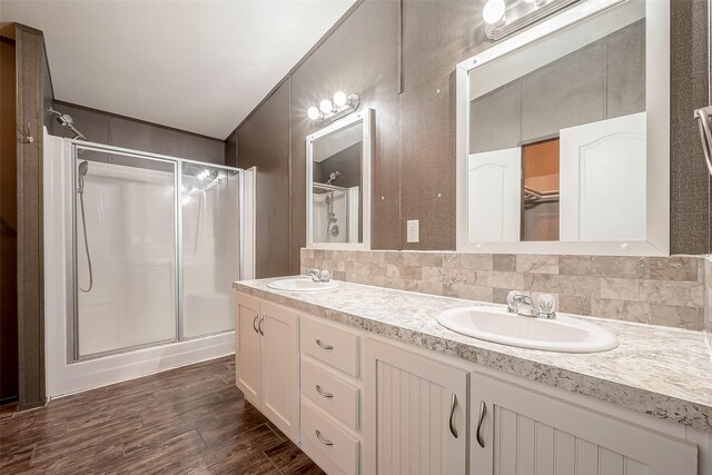 bathroom with backsplash, vanity, and a shower with shower door