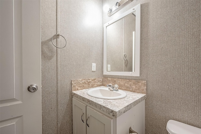 bathroom featuring vanity, tasteful backsplash, and toilet