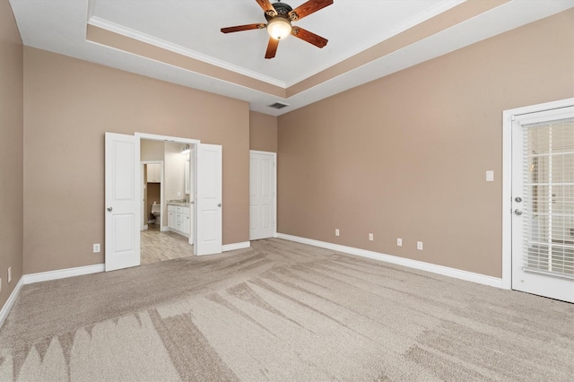 unfurnished bedroom featuring ceiling fan, a tray ceiling, crown molding, and light carpet