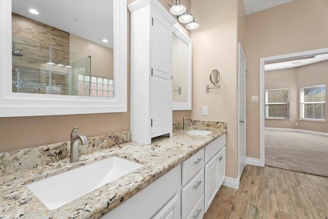 bathroom featuring hardwood / wood-style floors, an enclosed shower, and vanity