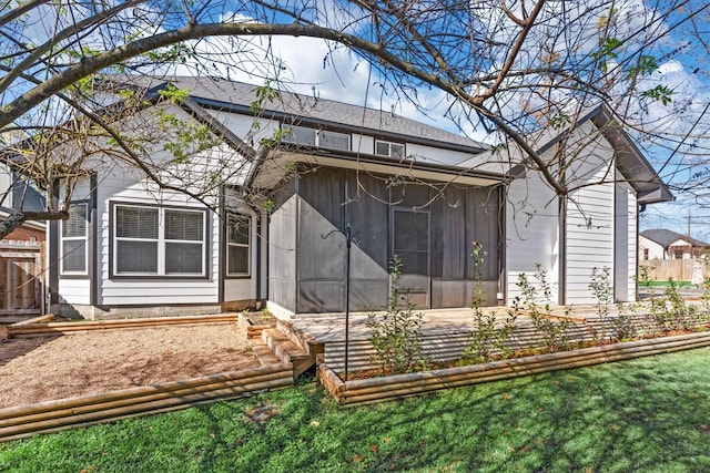 rear view of property with a sunroom and a yard