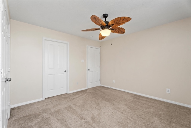 unfurnished bedroom with ceiling fan and light colored carpet