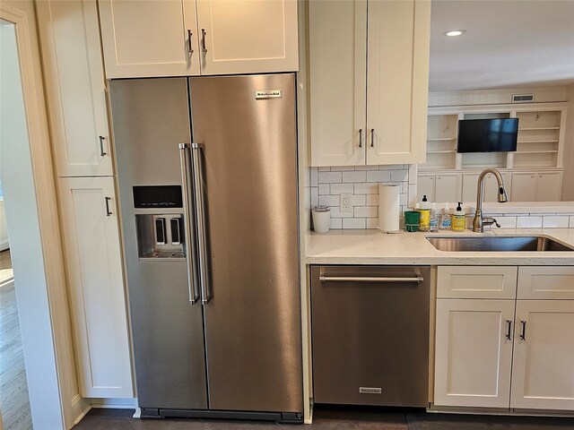 kitchen with white cabinets, appliances with stainless steel finishes, backsplash, and sink