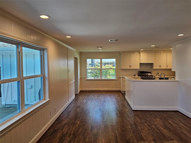 kitchen featuring crown molding, sink, dark wood-type flooring, white cabinets, and stainless steel range with gas stovetop