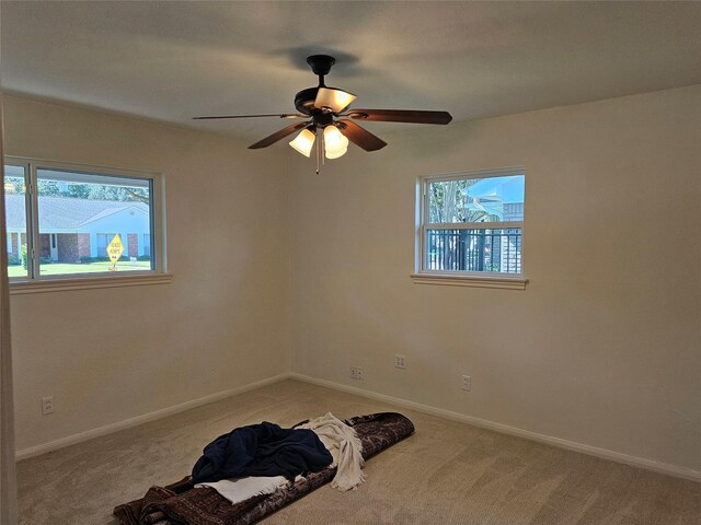 carpeted spare room with ceiling fan