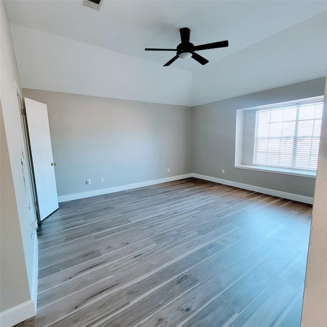 unfurnished room with ceiling fan, hardwood / wood-style floors, and vaulted ceiling