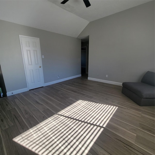 unfurnished living room featuring ceiling fan, dark wood-type flooring, and vaulted ceiling