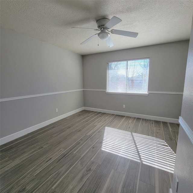 empty room featuring ceiling fan, wood-type flooring, and a textured ceiling