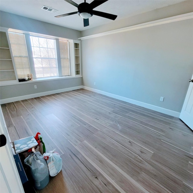 empty room with hardwood / wood-style floors and ceiling fan