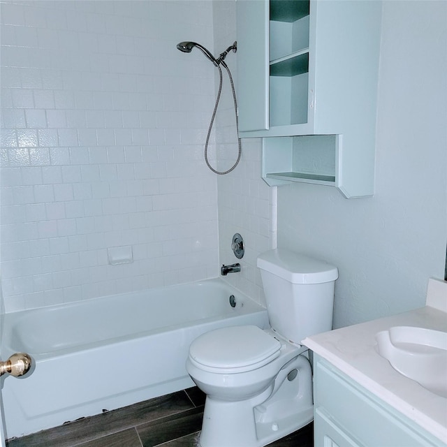 full bathroom with hardwood / wood-style floors, vanity, tiled shower / bath combo, and toilet