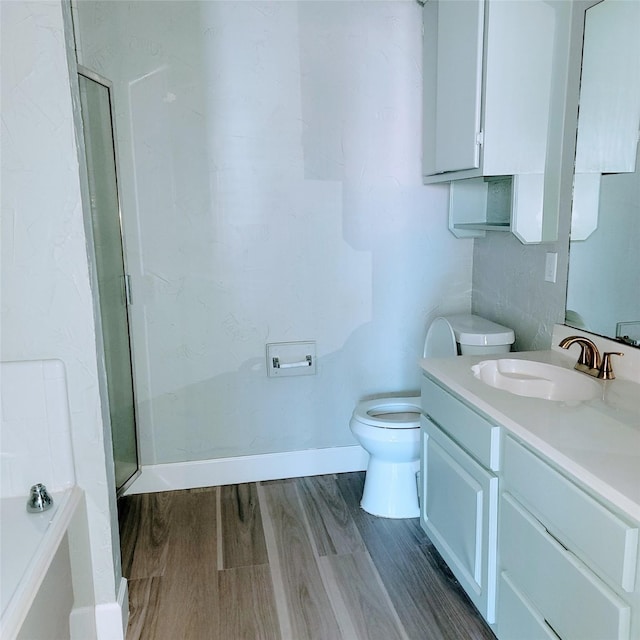 bathroom featuring hardwood / wood-style flooring, vanity, toilet, and a shower