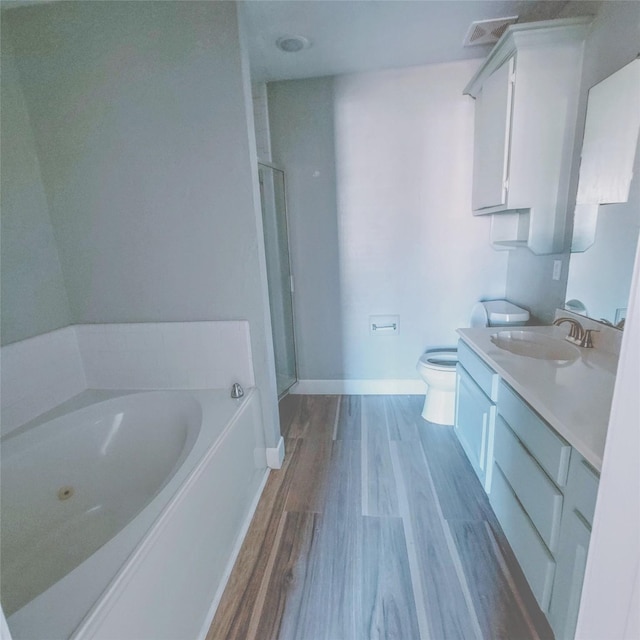 full bathroom with hardwood / wood-style flooring, toilet, vanity, and shower with separate bathtub