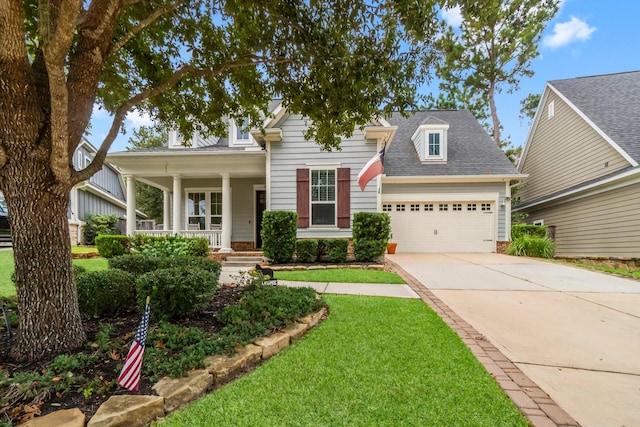 view of front facade with a porch, a garage, and a front lawn