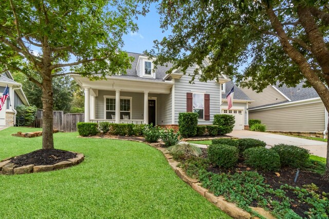 view of front of home with a front lawn, covered porch, and a garage