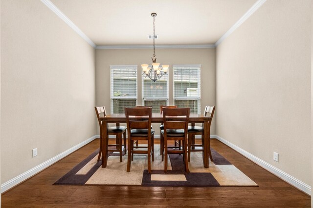 dining room featuring ornamental molding, dark hardwood / wood-style flooring, and a notable chandelier