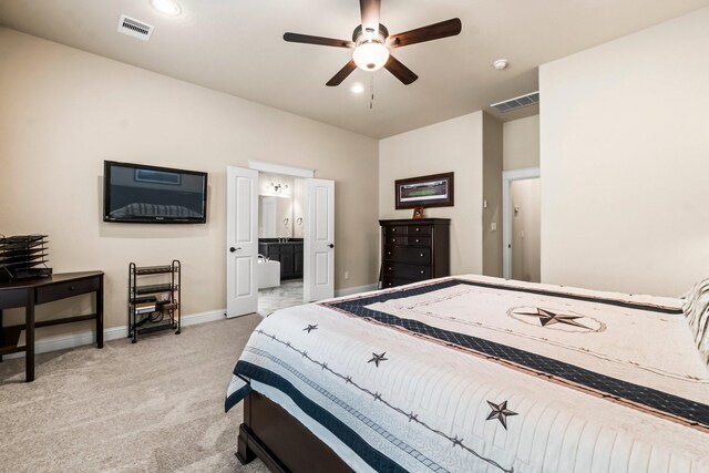 bedroom featuring ceiling fan, light colored carpet, and connected bathroom