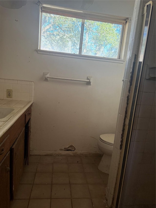 bathroom with tile patterned flooring, vanity, and toilet