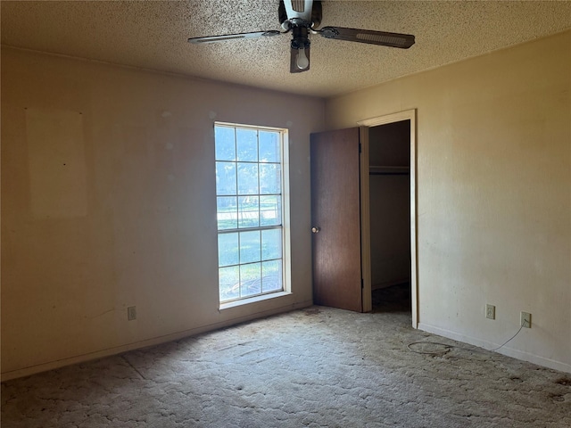 unfurnished bedroom with multiple windows, carpet, a textured ceiling, and ceiling fan