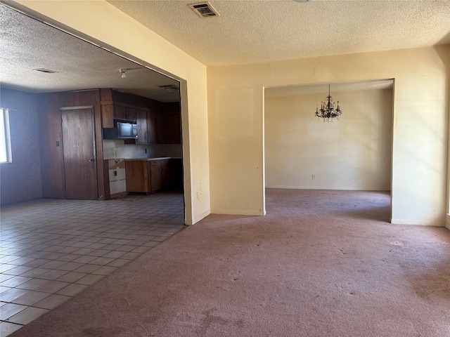 unfurnished living room featuring light tile patterned flooring and a textured ceiling