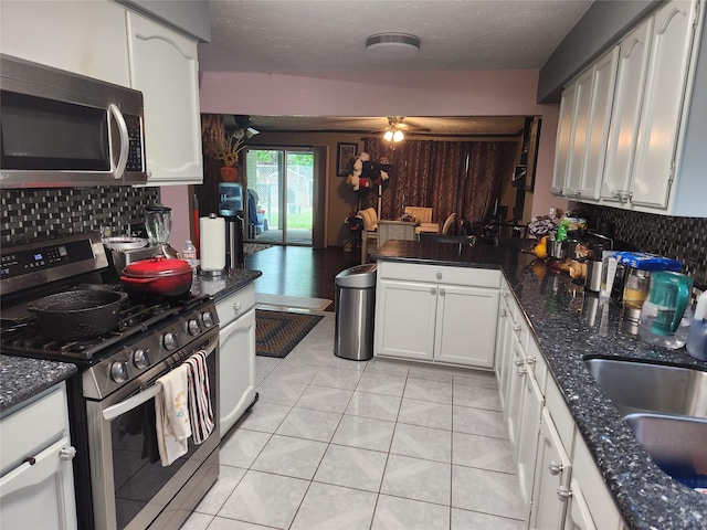 kitchen with decorative backsplash, appliances with stainless steel finishes, a textured ceiling, and white cabinetry