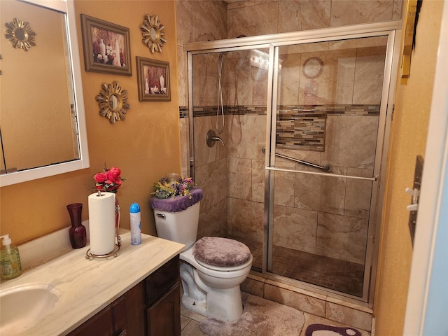 bathroom featuring tile patterned flooring, vanity, toilet, and a shower with door