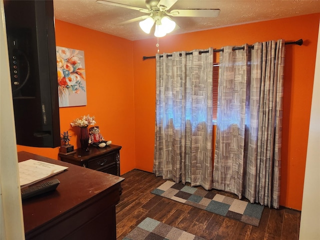 bedroom with ceiling fan, dark hardwood / wood-style flooring, and a textured ceiling