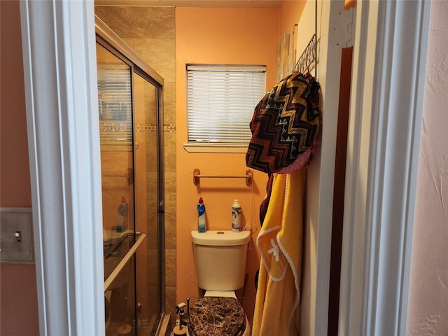 bathroom with toilet and a shower with shower door