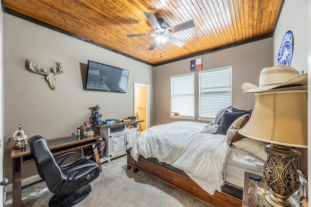 carpeted bedroom with ceiling fan, ornamental molding, and wooden ceiling