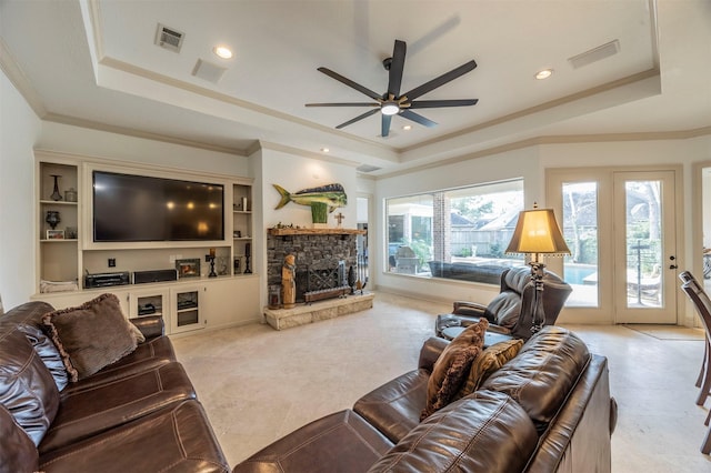 living room with ceiling fan, ornamental molding, a fireplace, and a raised ceiling