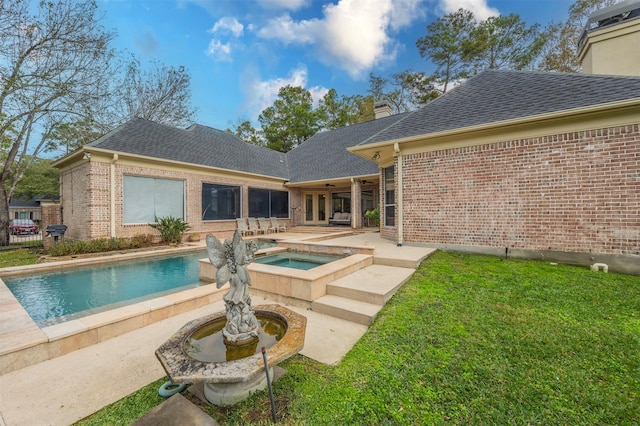 view of swimming pool with an in ground hot tub, a lawn, and a patio area