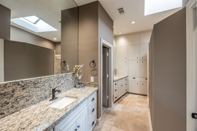 bathroom with vanity, a skylight, and decorative backsplash