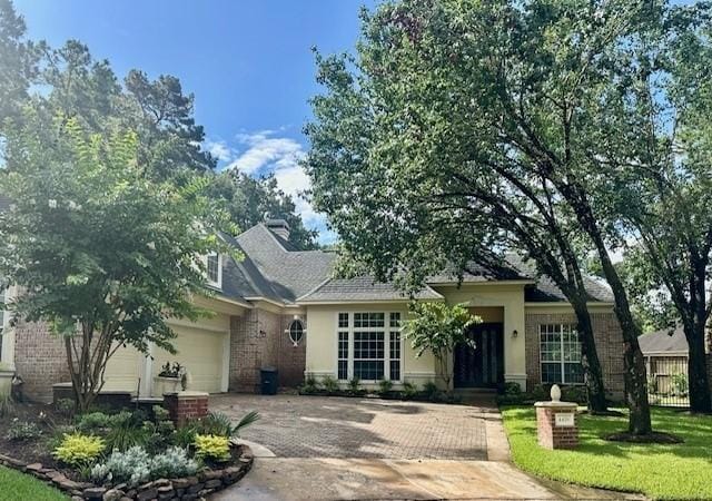 4418 Greens Court Way, Houston, TX 77339 - ranch-style house with an attached garage, brick siding, driveway, and a chimney