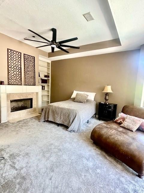 4418 Greens Court Way, Houston, TX 77339 - bedroom with carpet, a tile fireplace, a textured ceiling, and a ceiling fan