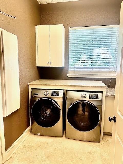 4418 Greens Court Way, Houston, TX 77339 - laundry room featuring cabinet space, independent washer and dryer, light tile patterned flooring, baseboards, and a textured wall