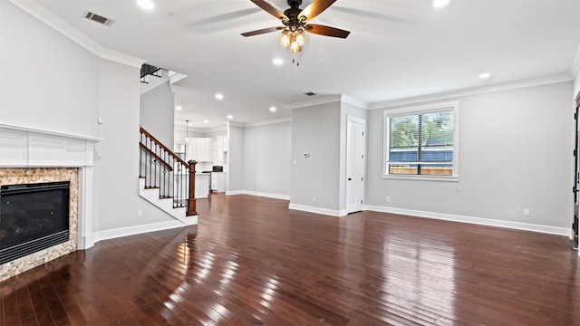 unfurnished living room featuring a fireplace, dark hardwood / wood-style flooring, ceiling fan, and crown molding