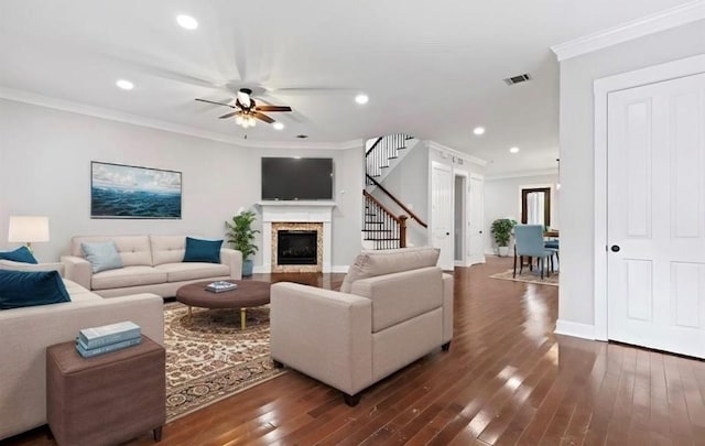 living room featuring dark hardwood / wood-style flooring, ceiling fan, and crown molding