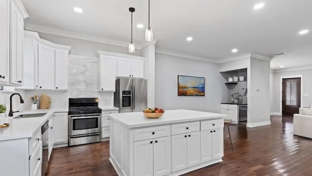 kitchen with white cabinetry, sink, a center island, stainless steel appliances, and decorative backsplash