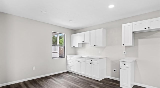 kitchen with dark hardwood / wood-style floors and white cabinetry