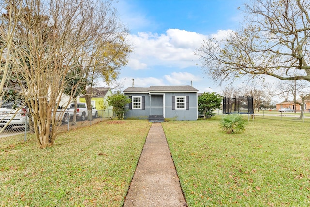 bungalow with a front yard and a trampoline