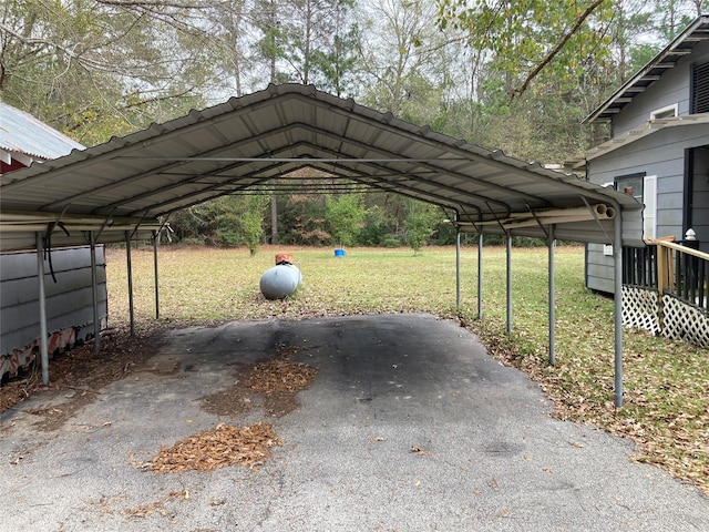 view of parking / parking lot with a yard and a carport