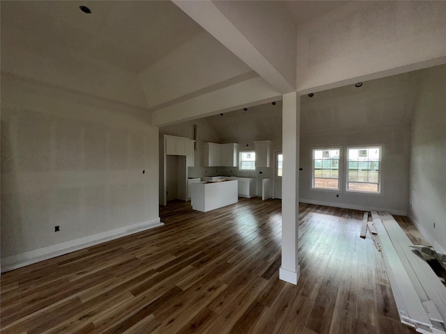 unfurnished living room with dark hardwood / wood-style floors and high vaulted ceiling