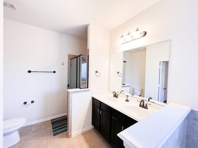 bathroom with tile patterned floors, vanity, toilet, and a shower with shower door